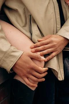 Hands Gently Holding Knee in Warm Interpersonal Gesture 写真素材