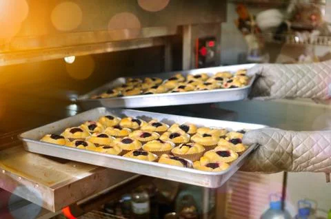Hands getting blueberry bread out of oven 스톡 사진
