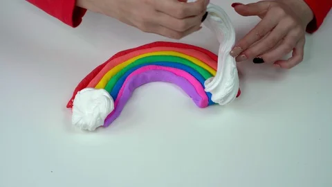 Hands of a girl making a rainbow slime on a white table. Stock Footage 127596773