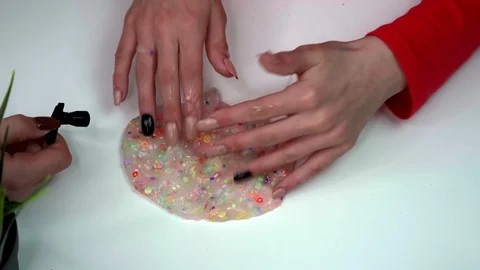 Hands of a girl playing with multi-colored slime Stock Footage 127596353
