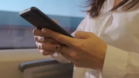 Hands girl on the train closeup using the phone. A woman rides a train and uses Stock Footage 118956155