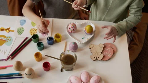 Hands of Girls Drawing Patterns on Dyed Easter Eggs at Home Stock Footage 327891952