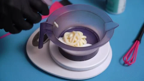 Hands in gloves add bleaching liquid to hair dye Vidéo 156071249