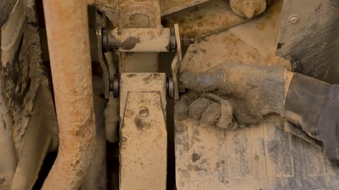 Hands in gloves and work clothes are repairing a spare part of a car in a garage Stock Footage 129841248