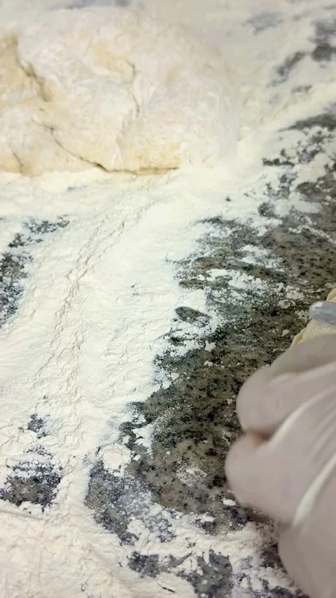 Hands in gloves are kneading dough on floured surface Stock-Footage 334593200