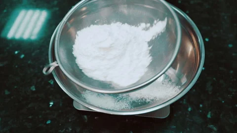 Hands in gloves are sifted through a sieve of flour into a bowl. Stock Footage 86422191