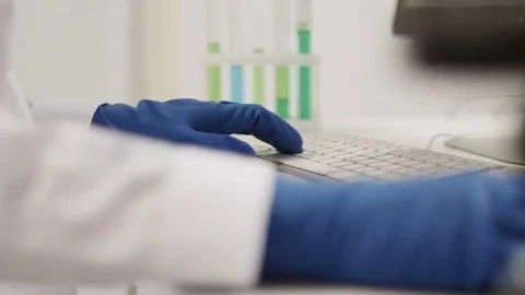 Hands in gloves are typing on the keyboard in a lab Vidéo 71110773