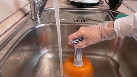 Hands with gloves cleaning sewer at kitchen faucet Stock Footage 161771985