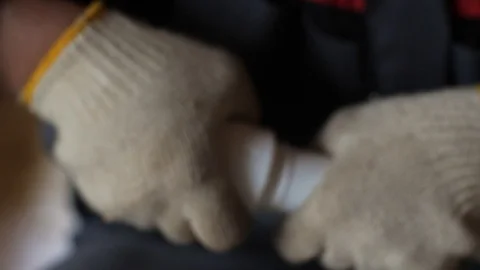 Hands in gloves connect plastic pipes together. 4k 60fps slow motion. Brazing of Vidéo 96583549
