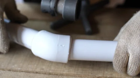 Hands in gloves connect plastic pipes together. 4k 60fps slow motion. Brazing of Stock Footage 96584237