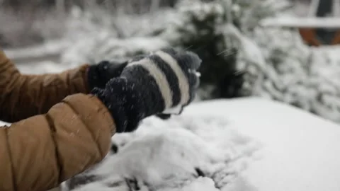 Hands in gloves creating a tiny snowman from 3 snowballs outdoor. Stock Footage 235727516