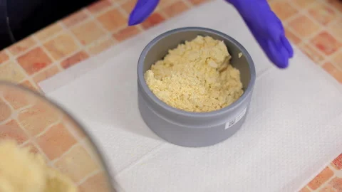 Hands in gloves filling container of corn powder with spoon Stock Footage 273401578