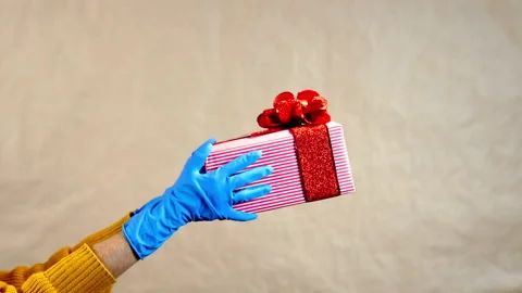Hands in gloves with a gift Stock Footage 142756375