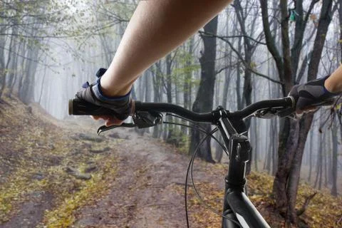 Hands in gloves holding handlebar of a bicycle. Mountain Bike cyclist riding Stock Photos