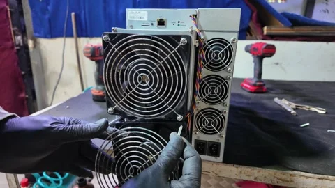 Hands with gloves install cooling grills onto a crypto mining computer machine Stock Footage 323992084