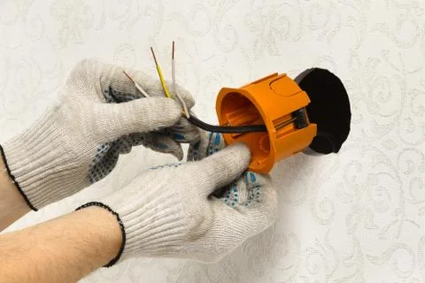 Hands in gloves install the socket box Stock Photos