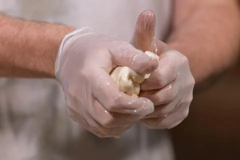 Hands in gloves kneading dough for baking 스톡 사진