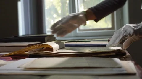 Hands in gloves leaf through old paper documents Stock Footage 243721272