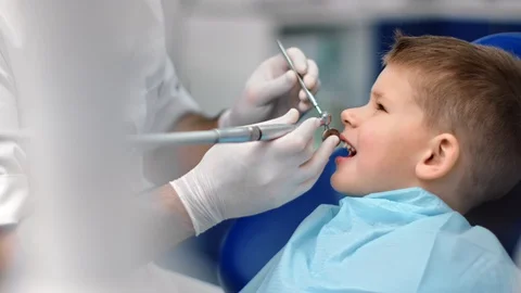 Hands in gloves of man dentist treating teeth to little boy. Shot on RED Raven Vídeos de archivo 127638955