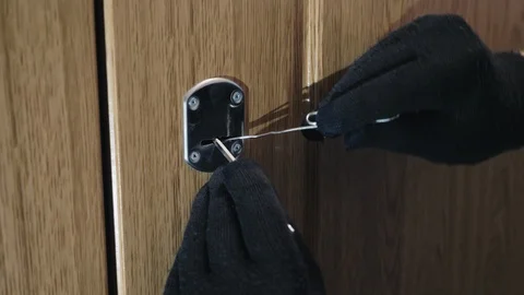 Hands in gloves opening the lock with picklocks Stock Footage 92309377