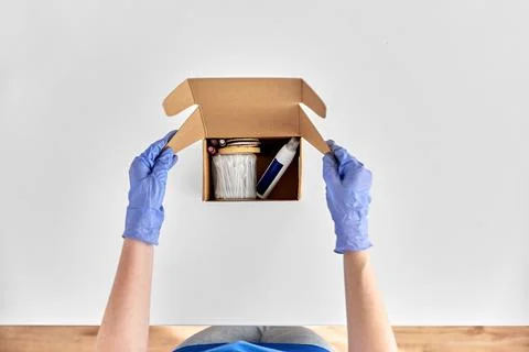 Hands in gloves packing parcel box with cosmetics Foto stock