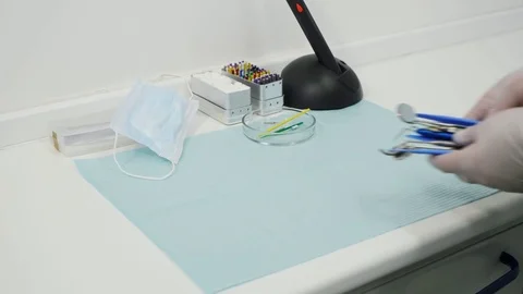Hands in the gloves put on the table a dental mirrors and excavators. Stock Footage 83622253