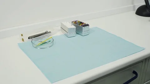 Hands in the gloves put on the table a dental mirrors, mask and excavators. Video stock 83622644