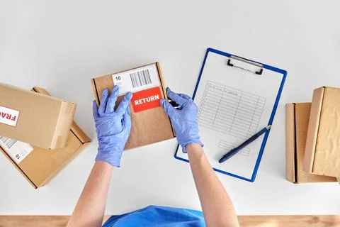 Hands in gloves with returned parcel box Stock Photos