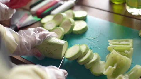 Hands in gloves slicing zucchini Video stock 186979912