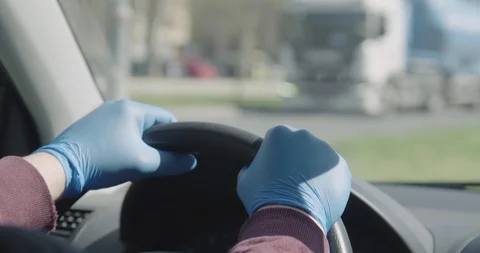 Hands in gloves on steering wheel driving a car covid 19 pandemic crisis Stock Footage 127854366