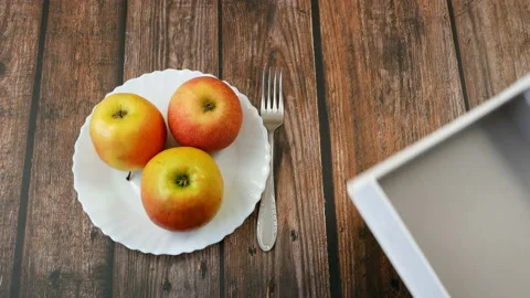 Hands in gloves take apple from plate and puts it in box, take away food concept Stock Footage 127562483