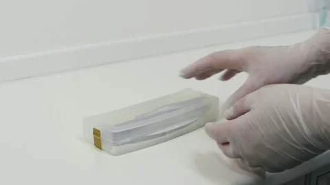 Hands in the gloves taking from the box on the table a dental drill. Stock Footage 83621793