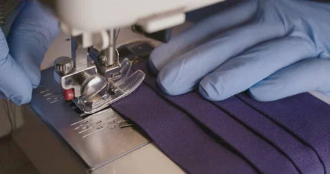Hands in gloves using sewing machine to sewing face mask Stock Footage 141318632
