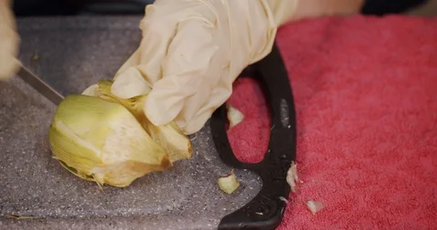 Hands with gloves while cutting artichokes - Close up Stock Footage 128959859