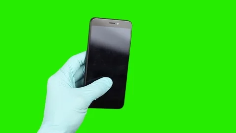 Hands in gloves wipe front of black phone or smartphone, green screen chromakey Видео 126998887