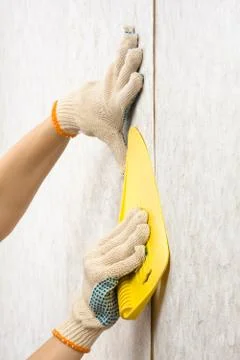Hands glue wallpaper on the wall Stock Photos