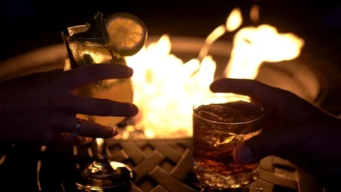 Hands grabbing cocktail drinks next to firepit slow motion travel relax Video stock 115545828