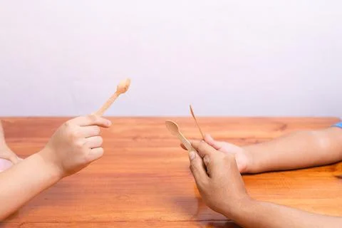 Hands grabbing spoons on the table Stock Photos