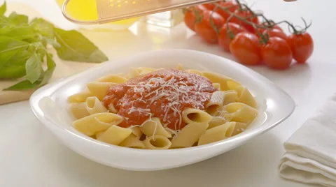 Hands grating cheese over yhe plate with penne pasta Stock Footage 67997490