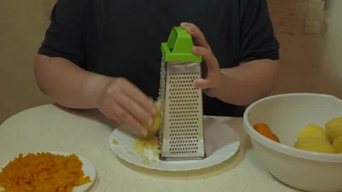Hands grating peeled boiled potato in home kitchen Vidéo 342362238