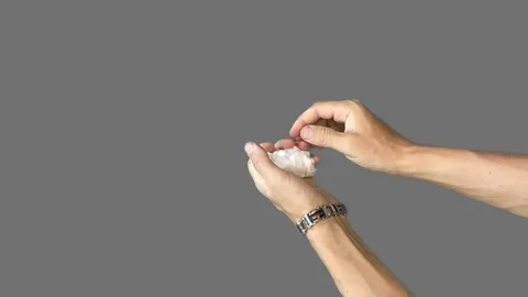 Hands on a gray background crumpled a sheet of paper and straightened it back Stock Footage 280441300