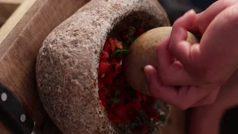 Hands grinding aji in a traditional stone mortar. Stock Footage 221216475