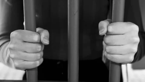 Hands grip prison bars tightly, tension and confinement Stock Footage 308078466