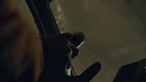 Hands grip the steering wheel in a dimly lit vehicle Video stock 302214019
