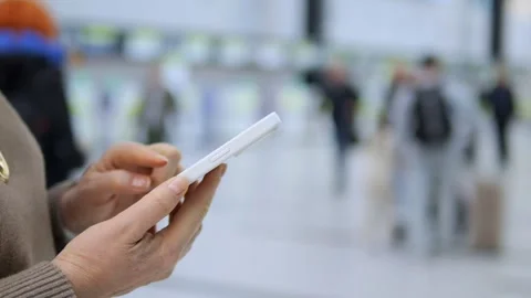 Hands grip tablet while crowd moves in background Stock Footage 340906629