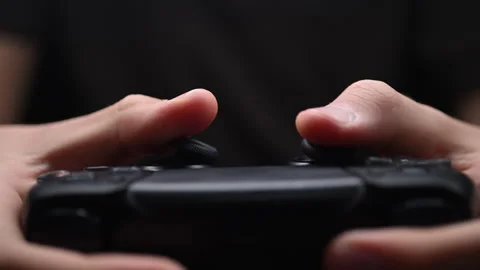 Hands gripping a black game controller with dramatic cinematic lighting. Stock Footage 319139092
