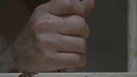 Hands Gripping Jail Cell Bars 4K Stock Footage 145956742