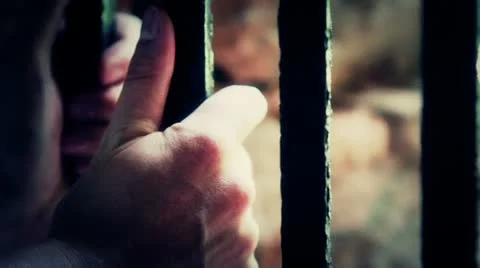 Hands gripping prison bars dramatic lighting Stock Footage 12517474