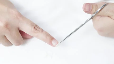 Hands gripping small scissors, trimming fingernails with precision on pristine Stock Footage 308522100
