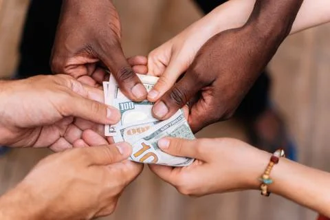 Hands of a group of people of different ethnicities holding a bill Stock Photos